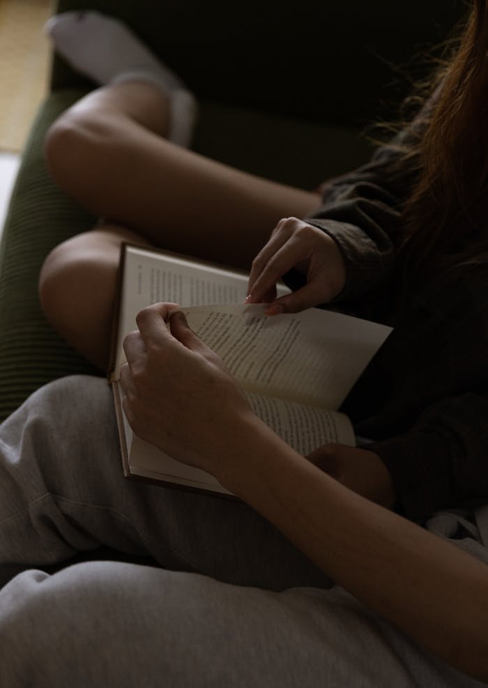 A couple enjoys a quiet reading session indoors, focused on a book and relaxation.